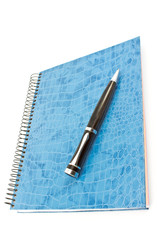 Blue spiral notebook with pen isolated on white