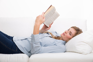 frau liest buch auf der couch