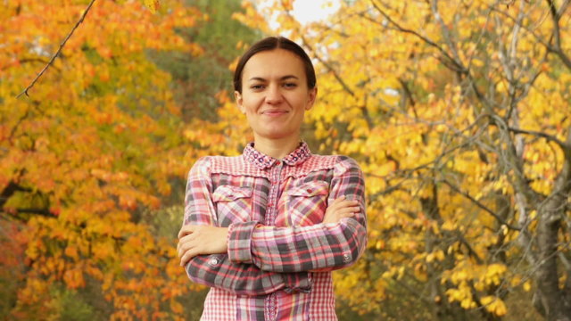 Portrait of young happy woman in beautiful autumn park