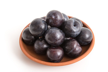 Blaue Pflaumen auf einem Tonteller