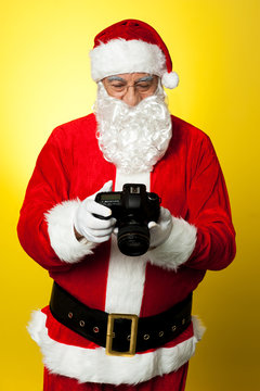 Santa checking pictures on his DSLR camera