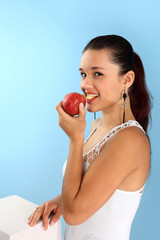 Piękna dziewczyna ugryzła jabłko. - obrazy, fototapety, plakaty