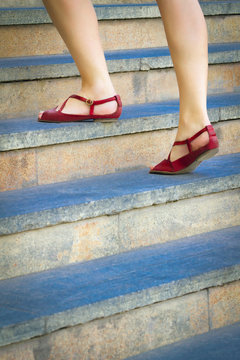 Woman stepping up a stairway. Lifestyle or social concept.