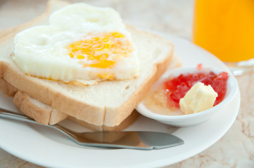 Fried eggs with hotdog Orange juice and toasts
