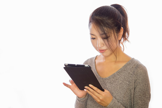 Asian young woman using iPad tablet pc ebook