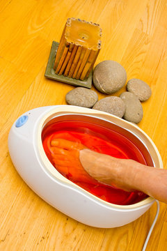 woman foot in paraffin bath at the spa