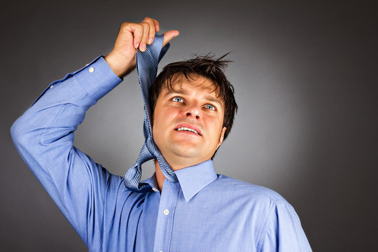 Young businessman trying to hang himself with tie