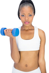 Serious woman in sportswear working out with dumbbell