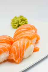 Salmon sushi nigiri on white plate and background with wasabi