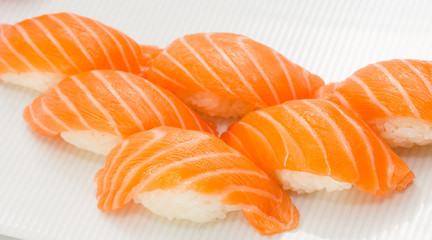 Salmon sushi nigiri on white plate and background with wasabi