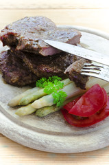 Beef steaks with purple asparagus