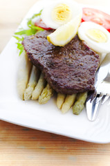 Beef steaks with purple asparagus