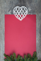 Pine tree with empty red paper sheet on old wooden background
