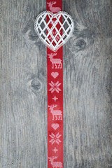 Fototapeta premium Red christmas ribbon on old wooden backround