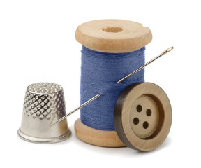 Spool of blue thread, needle, button  and thimble