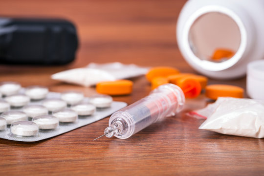 Set of narcotics and handgun on wooden table