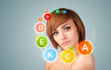 Pretty young girl with colorful vitamin icons and symbols