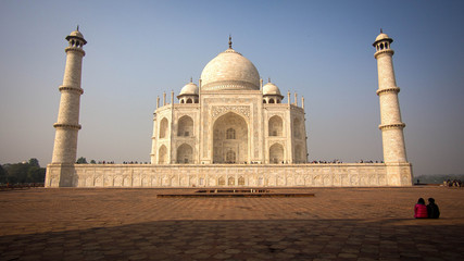 Fototapeta na wymiar A Couple Sitting in Front of the Taj Mahal in Agra, India