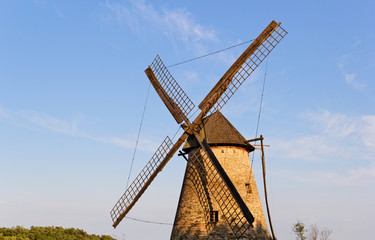 Fototapeta na wymiar Old wooden mill against the blue sky