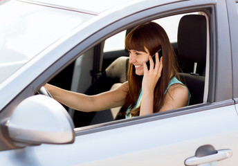 woman using phone while driving the car