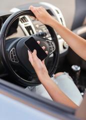 woman using phone while driving the car