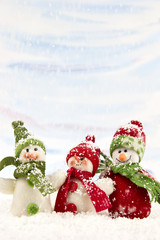 three smiling snowmen friends in the snow