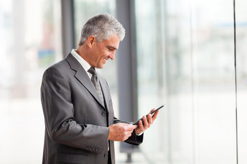 mid age businessman using tablet computer