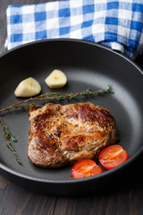 Steak with thyme, tomato and garlic.