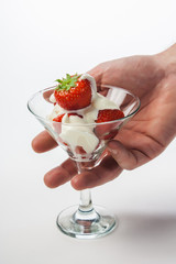 strawberries and cream in a glass on a white background