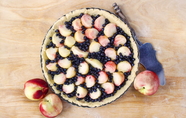 Top view of delicious tart filled with peaches and blueberries