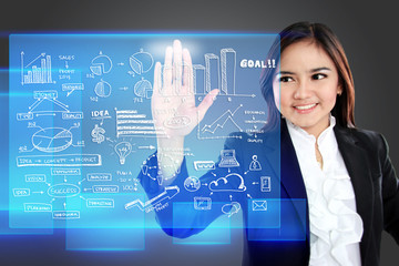 Businesswoman pointing to a graph on transparent touchscreen