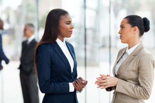 female colleagues having conversation in office