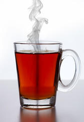 Glass cup of tea against white