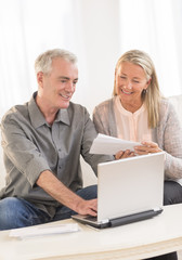 Couple With Laptop Calculating Bills At Home