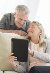 Senior Couple Using Digital Tablet At Home