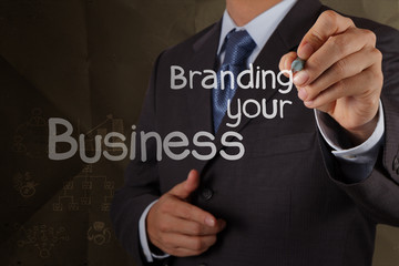 businessman hand writing branding your business with crumpled re