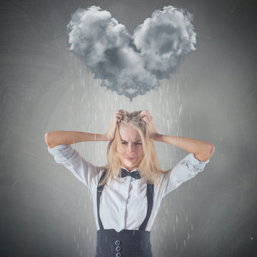 Cloud raining heart shape on top of sad Woman