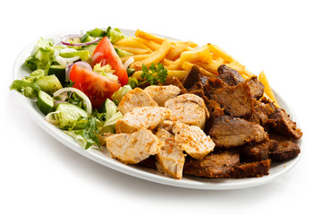 Grilled meat with French fries and vegetables