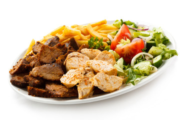 Grilled meat with French fries and vegetables