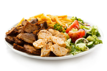 Grilled meat with French fries and vegetables