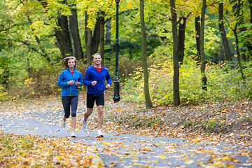 Fototapeta premium Urban leisure - woman and man running in park