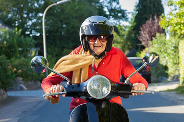 Senior lady riding her scooter. © belahoche