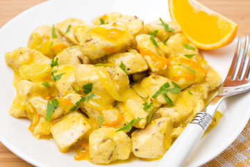 chicken fillet with orange sauce on a white plate