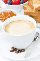 close-up of cappuccino and breakfast in the background