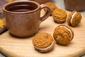 Pumpkin cookies with cream filling and a cup of tea