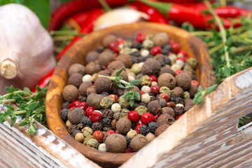 wooden bowl with dried peppers and spices, selective focus