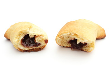 Fresh and sweet croissant with plum jam on white background