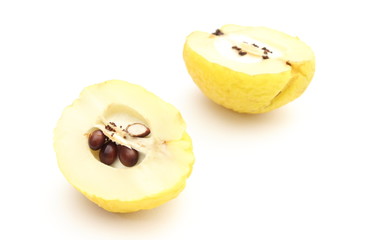 Two halves of yellow quince on a white background