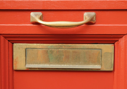 brass mailbox slot  on vivid red door