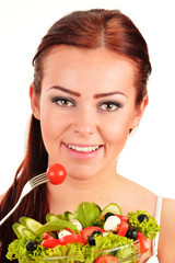 Young woman eating vegetable salad